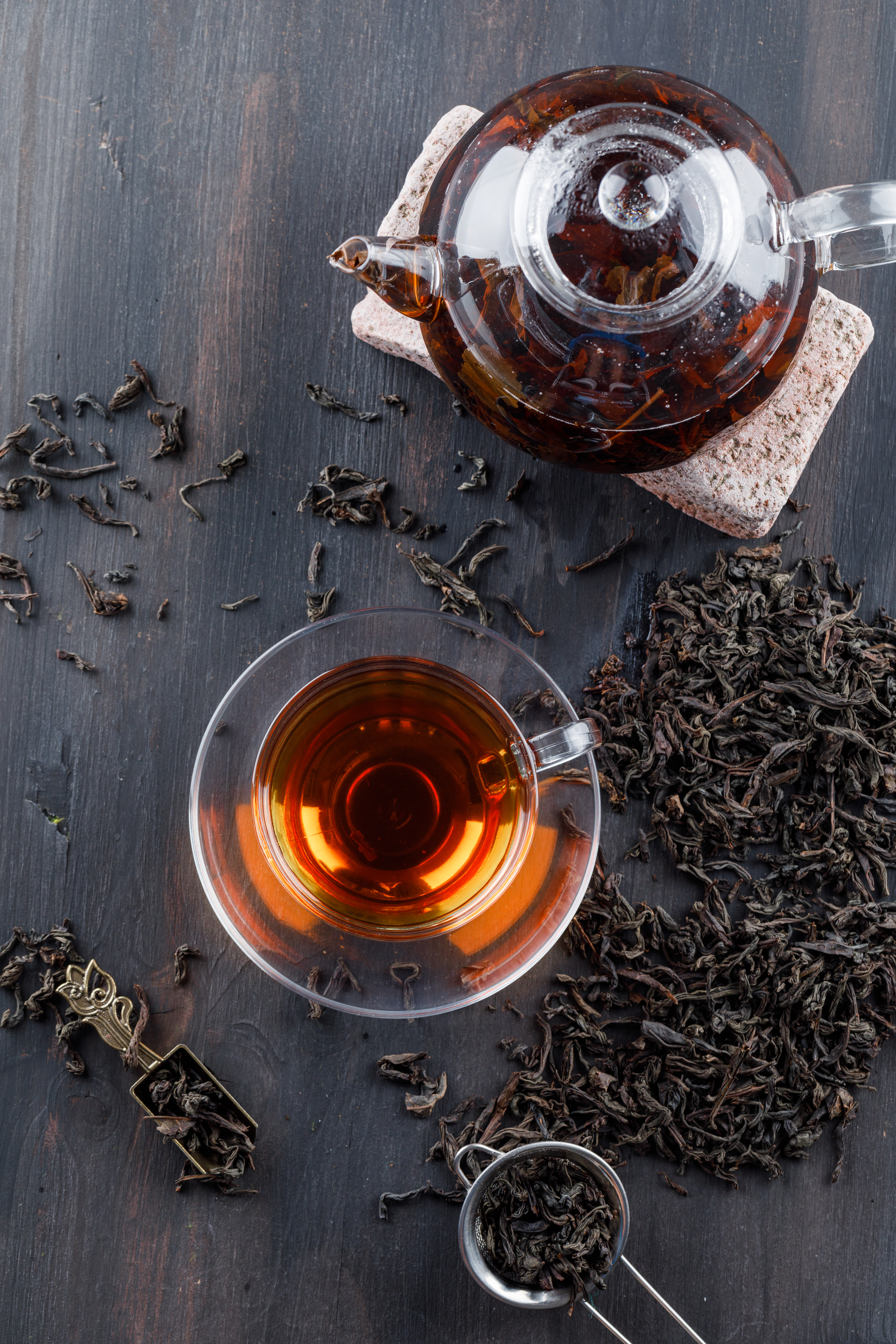 black-tea-with-dry-tea-brick-teapot-cup-wooden-surface-top-view